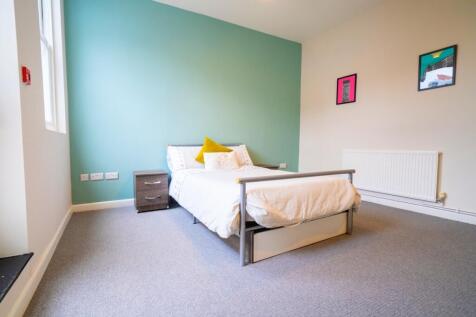 A bright and inviting bedroom featuring a large...