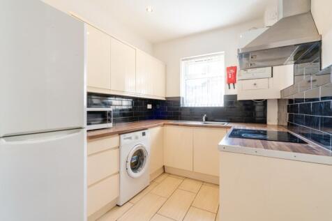 Bright and clean kitchen featuring white cabine...