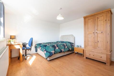 A bright, well-lit double bedroom featuring a c...