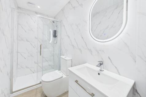 Modern bathroom featuring a glass-enclosed show...