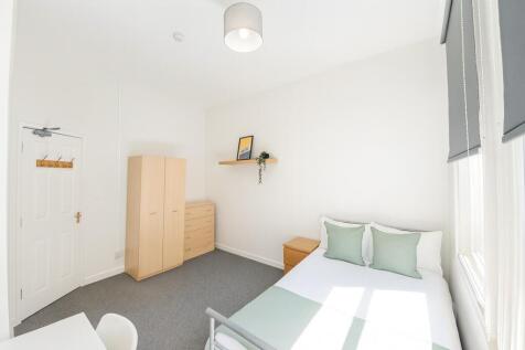 Bright and minimalist bedroom featuring a neatl...