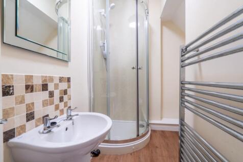 A clean and modern bathroom featuring a corner ...