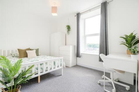 Bright and airy bedroom featuring a white bed w...