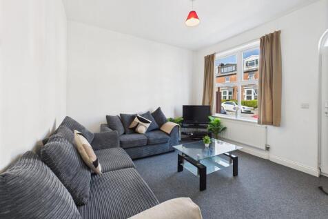 A bright and spacious living room featuring lar...