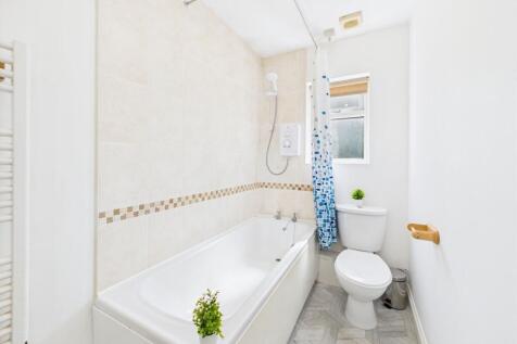 Bright and tidy bathroom featuring a bathtub wi...