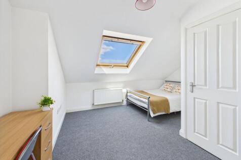 Bright and airy bedroom featuring a large skyli...