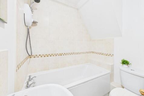 A clean and modern bathroom with a bathtub, toi...