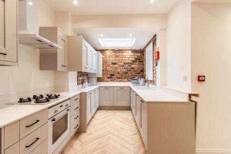 Modern and bright kitchen featuring white cabin...