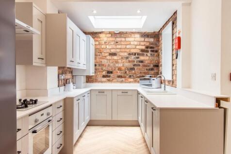 Bright and modern kitchen featuring white cabin...