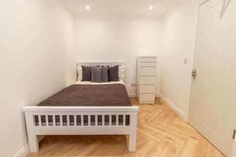 A bright, neatly maintained bedroom featuring a...