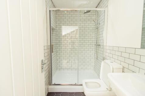 Modern bathroom featuring white subway tiles, a...