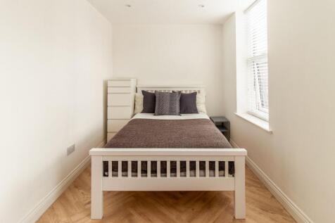 A bright and tidy single bedroom with a comfort...