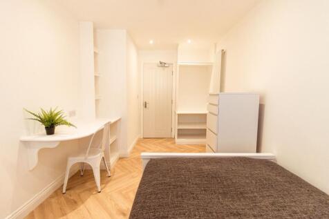 A bright and well-maintained bedroom featuring ...