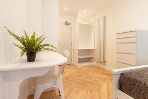 A bright, tidy room featuring a white desk with...