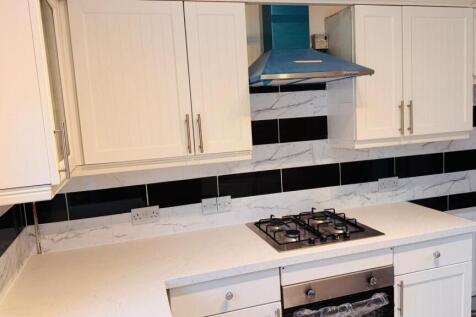 A modern kitchen with a white countertop and bl...
