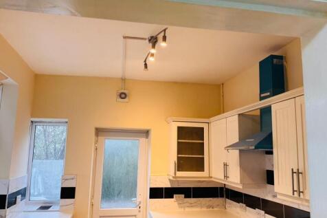 A well-lit kitchen with modern cabinets and app...