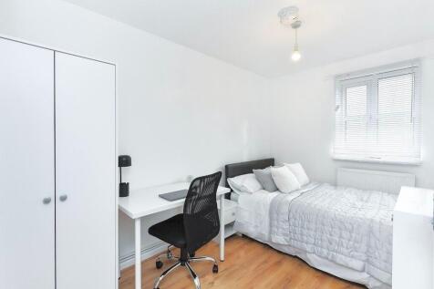 A bright, minimalist bedroom featuring a double...