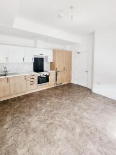 Bright, modern open-plan kitchen with light woo...