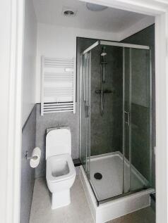 Modern compact bathroom with a glass-enclosed s...