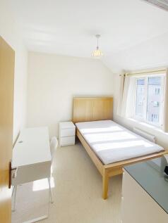 Bright, neatly presented bedroom with a wooden ...