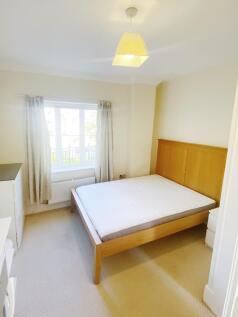 Bright, neutral double bedroom featuring a wood...