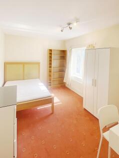Bright, neatly furnished double bedroom with a ...