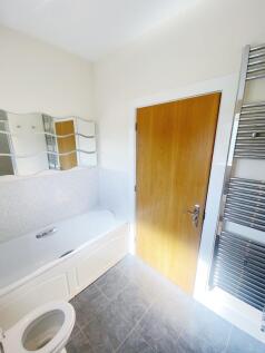 Bright, modern bathroom with a white panelled b...