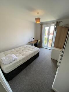 A cozy bedroom featuring a single bed with a ma...