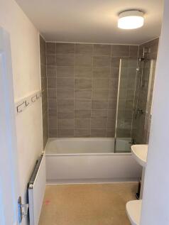 A clean, modern bathroom featuring a bathtub wi...