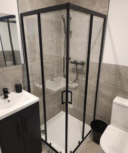 Modern bathroom featuring a spacious shower enc...