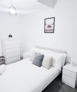 Bright, modern bedroom with a neatly made doubl...