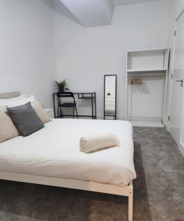 A clean and modern bedroom featuring a comforta...
