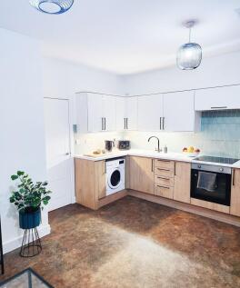 Bright, modern kitchen with white gloss upper c...