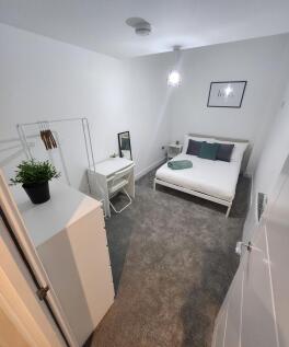 A well-maintained, bright bedroom featuring a c...