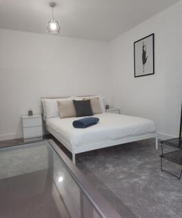 A modern, minimalist master bedroom featuring a...
