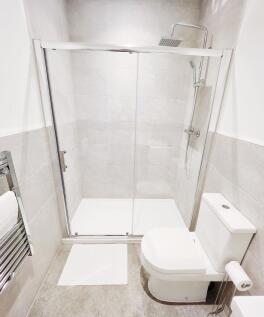 Bright, modern bathroom featuring a walk-in sho...