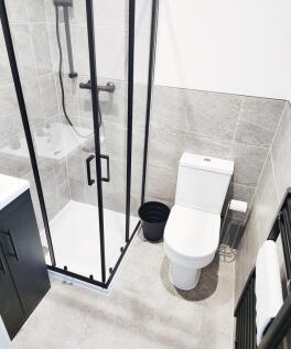 Modern tiled bathroom with a framed glass showe...