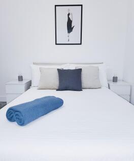 Bright, minimalist double bedroom with a neatly...