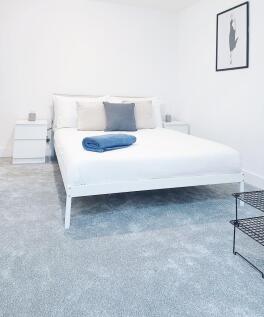 Bright, modern master bedroom with a white doub...