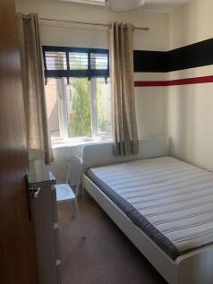 A bright and cozy bedroom featuring a large win...