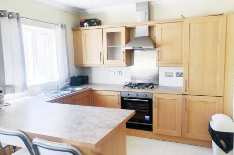 Bright modern kitchen with light wood cabinetry...