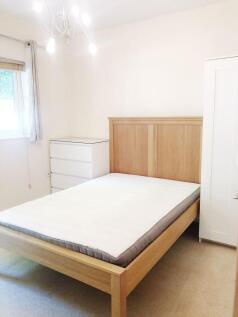Bright, neat double bedroom with a light wooden...