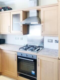 Bright fitted kitchen with light wood cabinetry...