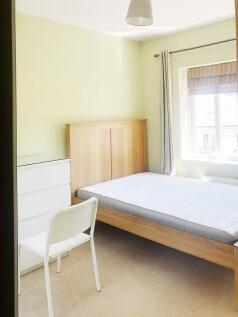 Bright, neatly presented bedroom with a wooden ...