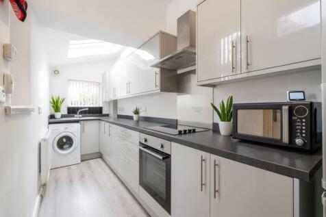 Modern, bright kitchen featuring sleek white ca...