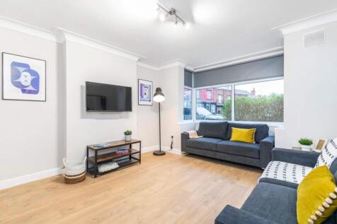 A modern, well-lit living room featuring comfor...