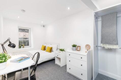 A bright and welcoming bedroom featuring a sing...