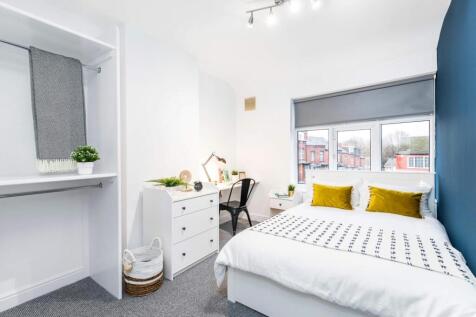 A tidy and well-lit single bedroom featuring a ...