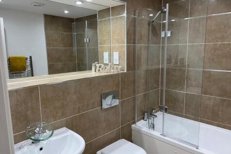 A modern and spacious bathroom featuring a rela...