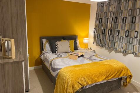 A bright and inviting double bedroom with styli...